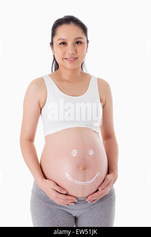 Ein lächelndes Gesicht auf schwangere Frau Bauch Stockfoto