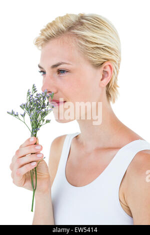 Wunderschöne blonde Frau Blumen riechen Stockfoto