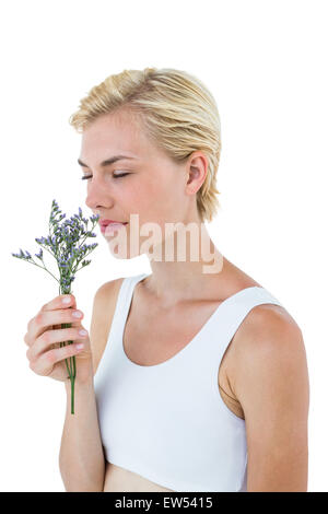 Wunderschöne blonde Frau Blumen riechen Stockfoto