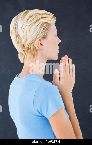 Hübsche blonde Frau beten Stockfoto