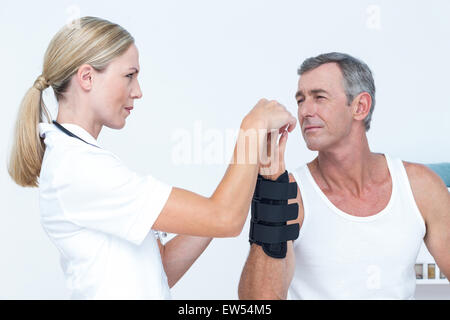 Arzt untersucht einen Mann Handgelenk Stockfoto