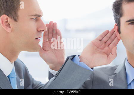 Geschäftsmann Geheimnis zu seinem Kollegen sagen Stockfoto