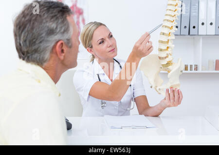 Arzt zeigen ihren Patienten ein Modell der Wirbelsäule Stockfoto