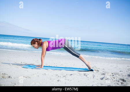 Brünette beim Yoga auf Gymnastikmatte Stockfoto