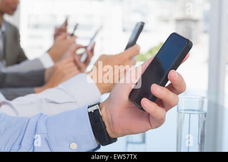 Business-Team mit ihrem Mobiltelefon Stockfoto