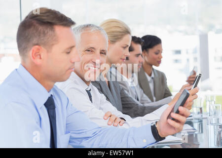 Business-Team mit ihrem Mobiltelefon Stockfoto