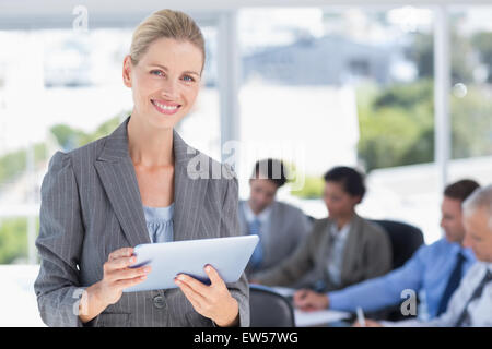 Geschäftsfrau hält Tablet und Blick in die Kamera Stockfoto