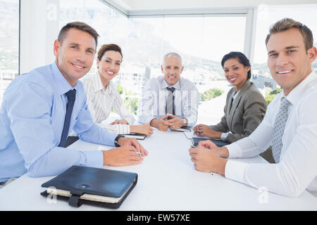 Business-Team zusammen um den Tisch herum sitzen Stockfoto