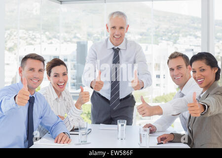 Business-Team lächelnd in die Kamera zeigen, Daumen nach oben Stockfoto
