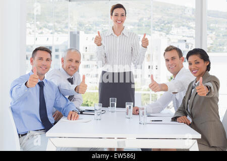 Business-Team lächelnd in die Kamera zeigen, Daumen nach oben Stockfoto