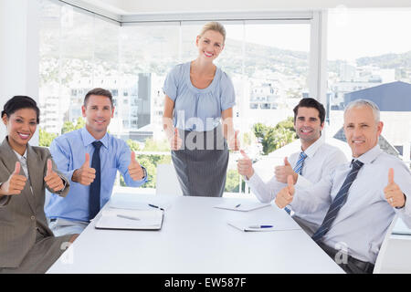 Business-Team lächelnd in die Kamera zeigen, Daumen nach oben Stockfoto