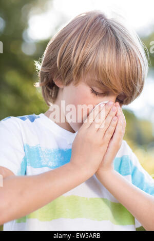 Kleiner Junge bläst seine Nase Stockfoto