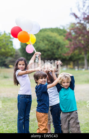 Glückliche Kinder mit Luftballons Stockfoto