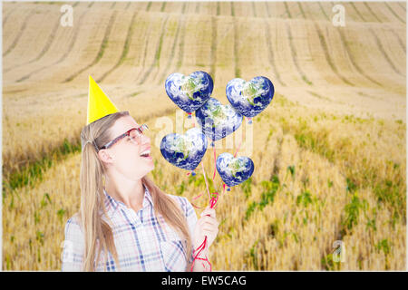 Zusammengesetztes Bild geeky Hipster halten rote Luftballons Stockfoto