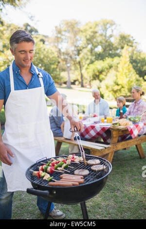 Glücklicher Mann Grill für seine Familie zu tun Stockfoto