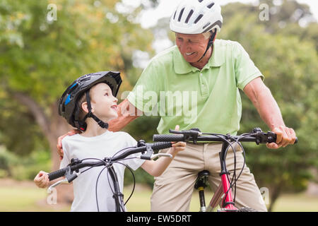 Glücklich Opa mit seiner Enkelin auf ihr Fahrrad Stockfoto