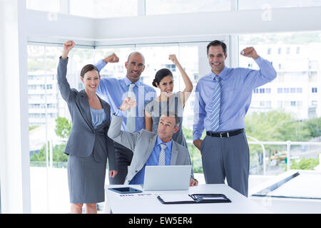 Business-Team feiert und Blick in die Kamera Lächeln Stockfoto