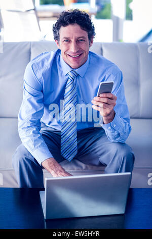 Geschäftsmann mit Laptop und smartphone Stockfoto