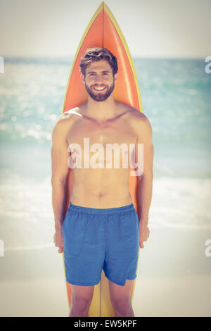 Gut aussehend Surfer Mann stand vor seinem Surfbrett Stockfoto