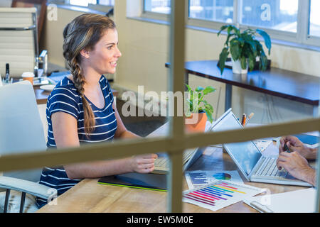 Lächelnde Kollegen zusammenarbeiten auf laptop Stockfoto