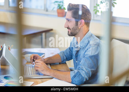 Lächelnde Geschäftsmann auf laptop Stockfoto