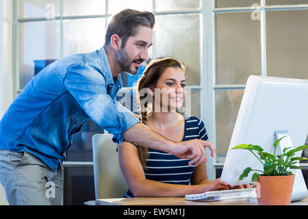 Lächelnde Kollegen zusammen arbeiten am computer Stockfoto