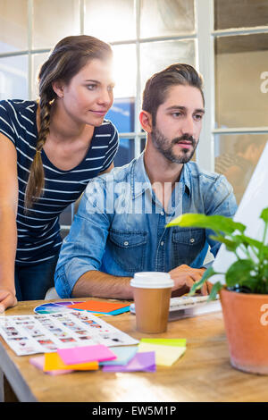 Lächelnde Kollegen zusammen arbeiten am computer Stockfoto