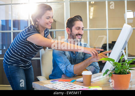 Lächelnde Kollegen zusammen arbeiten am computer Stockfoto