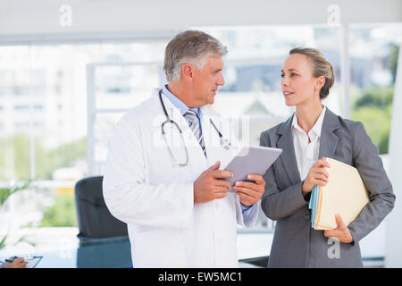 Sicher Arzt und hübsche Geschäftsfrau diskutieren Stockfoto