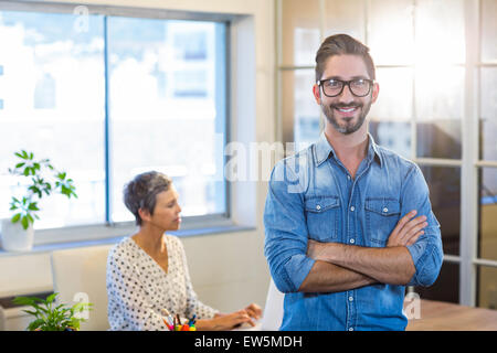 Lächelnd Mann stehend Arme gekreuzt mit seinem Partner hinter Stockfoto