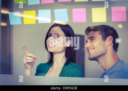 Kollegen betrachten Haftnotizen Stockfoto