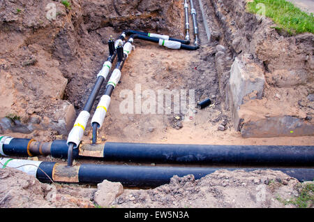 moderne Kunststofftechnik schwarz Heizungsrohre im Graben in der Nähe von Stadthaus Stockfoto