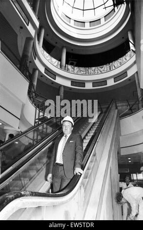 Eldon Garten Shopping Center, Newcastle Upon Tyne, Tyne and Wear. Center Manager Herr Albion kleine ist auf den wichtigsten Rolltreppe unter der beeindruckenden Kuppel abgebildet, wie Arbeiter den letzten zum Einkaufszentrum Schliff. 20. Februar 1989. Stockfoto