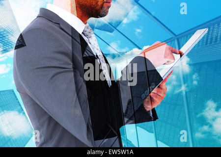 Zusammengesetztes Bild der Geschäftsmann mit seinem TabletPC Stockfoto