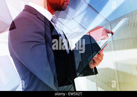 Zusammengesetztes Bild der Geschäftsmann mit seinem TabletPC Stockfoto