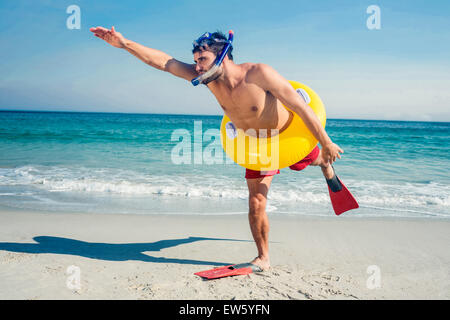Mann mit Flossen und Gummiring am Strand Stockfoto