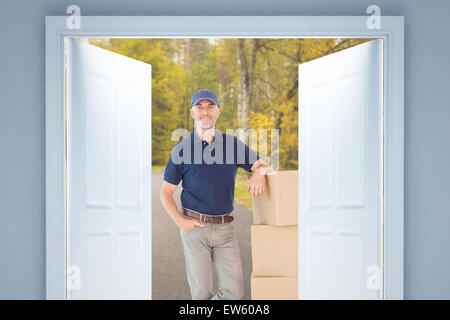 Zusammengesetztes Bild zufrieden Lieferung Mann stützte sich auf Haufen von Kartons Stockfoto