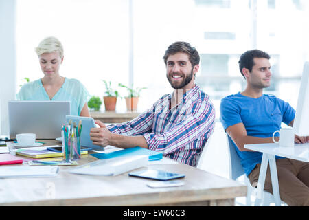 Geschäftsmann hält eine Tablette im Büro Stockfoto