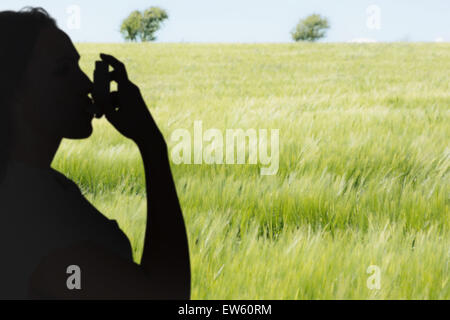 Zusammengesetztes Bild von asthmatischen Brünette mit ihrem Inhalator Stockfoto