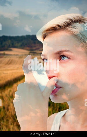 Zusammengesetztes Bild blonde Frau, die ihren Inhalator Stockfoto