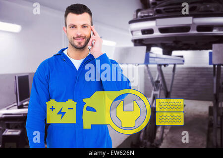 Zusammengesetztes Bild des lächelnden männlichen Mechaniker mit seinem Mobiltelefon Stockfoto