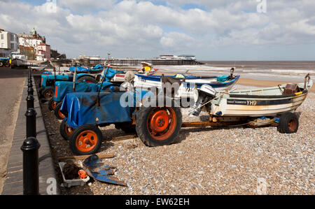 Angeln, Boote und Traktoren am Cromer Beach, Norfolk, England, UK, mit dem Meer und Pier im Hintergrund Stockfoto