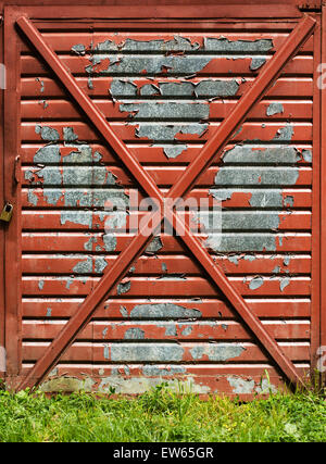 Farbe fällt nach unten, auf einem alten Garagentor. Stockfoto