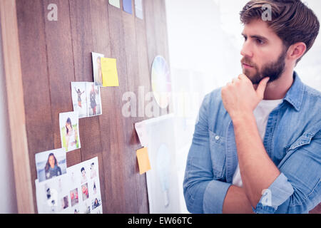 Verwirrt Geschäftsmann sucht Post seinen an der Wand Stockfoto