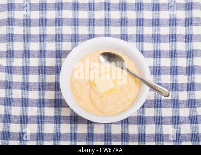 Eine Schale mit heißer Grütze gelb mit einem Klaps von Butter schmelzen Stockfoto