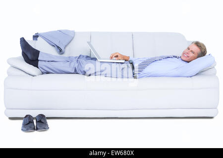 Geschäftsmann auf Sofa mit seinem Laptop in die Kamera Lächeln Stockfoto