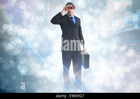 Zusammengesetztes Bild der Geschäftsmann mit dem Fernglas eine Aktentasche mit gedrückter Stockfoto