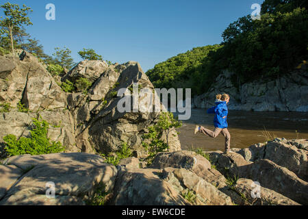 Eine Frau Wanderungen und Felsen klettert auf dem Bily Goat Trail in Great Falls Park, Maryland. Stockfoto