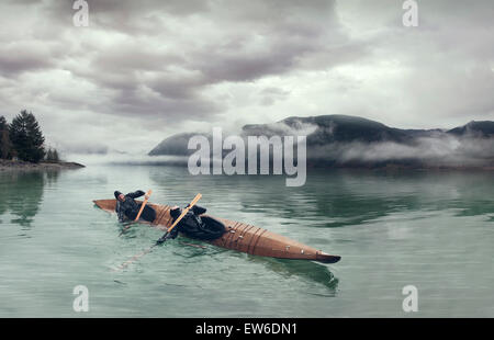 Zwei Kajakfahrer führen eine doppelte Rolle in einem Haut-on-Frame Kajak am Puget Sound. Stockfoto