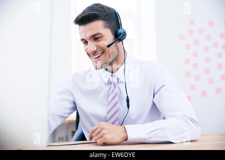 Porträt eines männlichen Betreiber mit Kopfhörer mit PC im Büro Stockfoto